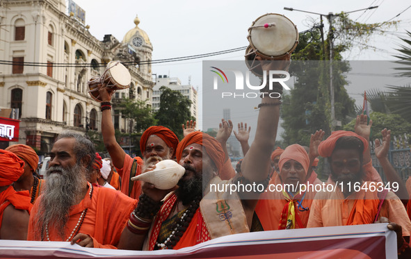 A sadhu, or a Hindu holy man, blows into a conch shell during a protest near a stage where junior doctors hold a hunger strike to protest ag...