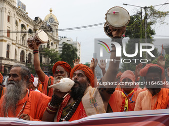 A sadhu, or a Hindu holy man, blows into a conch shell during a protest near a stage where junior doctors hold a hunger strike to protest ag...