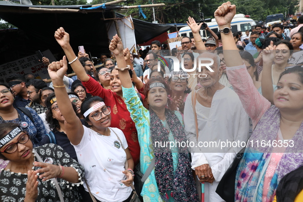 Citizens shout slogans during a protest near a stage where junior doctors hold a hunger strike to protest against the rape and murder of a P...