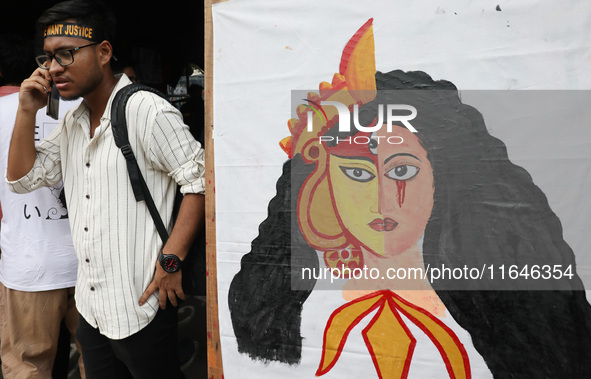 A citizen speaks on his mobile phone during a protest near a stage where junior doctors hold a hunger strike to protest against the rape and...