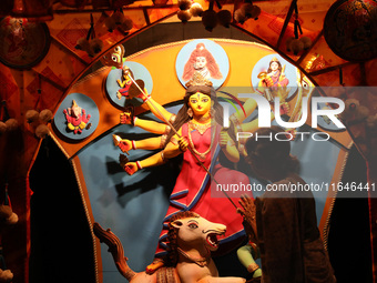 A Hindu senior citizen woman from an old age home offers prayer in front of an idol of the Hindu goddess Durga inside a tram compartment con...