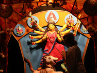 A Hindu senior citizen woman from an old age home offers prayer in front of an idol of the Hindu goddess Durga inside a tram compartment con...