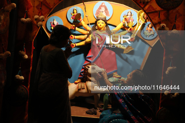 A Hindu senior citizen woman from an old age home adorns an idol of the Hindu goddess Durga inside a tram compartment converted to a ''panda...