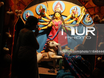 A Hindu senior citizen woman from an old age home adorns an idol of the Hindu goddess Durga inside a tram compartment converted to a ''panda...