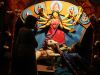 A Hindu senior citizen woman from an old age home adorns an idol of the Hindu goddess Durga inside a tram compartment converted to a ''panda...