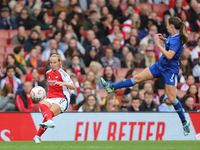 Bath Mead of Arsenal kicks the ball as Everton's Clare Wheeler jumps to block during the Barclays FA Women's Super League match between Arse...