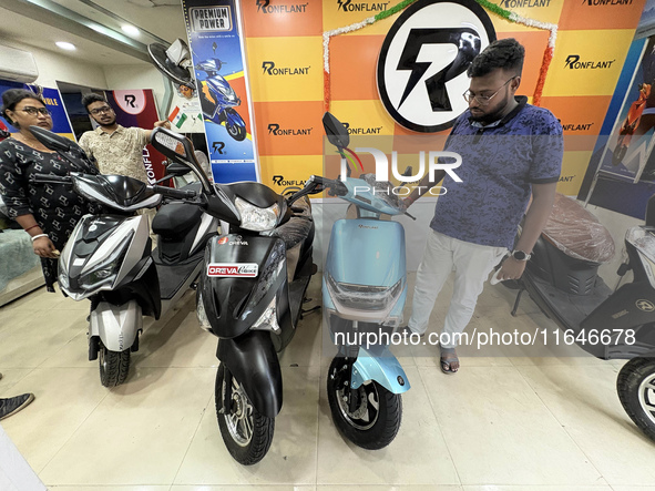 A person looks at an electric scooter at a showroom in Kolkata, India, on October 7, 2024. 