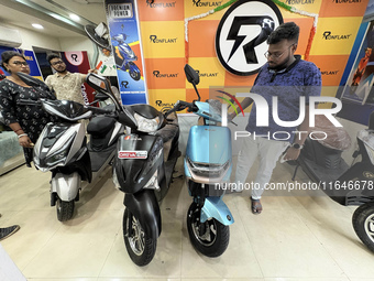 A person looks at an electric scooter at a showroom in Kolkata, India, on October 7, 2024. (