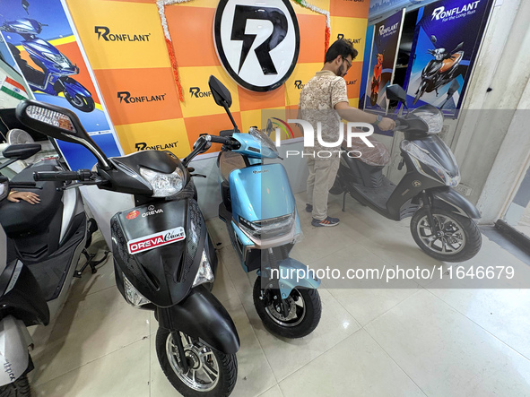 A person looks at an electric scooter at a showroom in Kolkata, India, on October 7, 2024. 