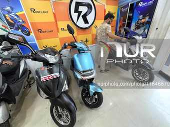 A person looks at an electric scooter at a showroom in Kolkata, India, on October 7, 2024. (