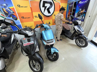 A person looks at an electric scooter at a showroom in Kolkata, India, on October 7, 2024. (