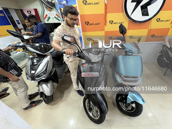 A person looks at an electric scooter at a showroom in Kolkata, India, on October 7, 2024. 