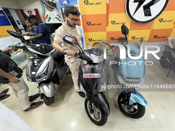 A person looks at an electric scooter at a showroom in Kolkata, India, on October 7, 2024. (