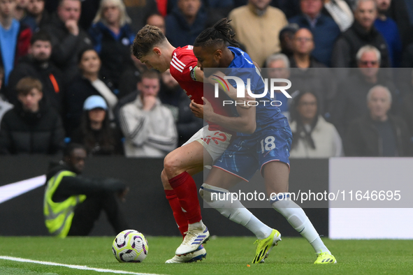 Ryan Yates of Nottingham Forest shields the ball from Christopher Nkunku of Chelsea during the Premier League match between Chelsea and Nott...