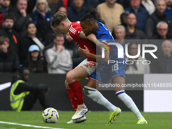 Ryan Yates of Nottingham Forest shields the ball from Christopher Nkunku of Chelsea during the Premier League match between Chelsea and Nott...