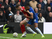 Ryan Yates of Nottingham Forest shields the ball from Christopher Nkunku of Chelsea during the Premier League match between Chelsea and Nott...