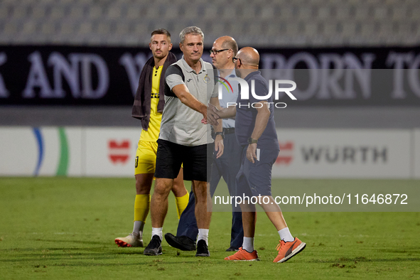 In Ta' Qali, Malta, on October 2, 2024, Branko Nisevic, head coach of Hibernians, shakes hands with Hamrun Spartans assistant coach Alessand...