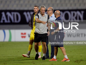 In Ta' Qali, Malta, on October 2, 2024, Branko Nisevic, head coach of Hibernians, shakes hands with Hamrun Spartans assistant coach Alessand...