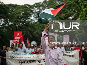 The Palestine Solidarity Committee, Bangladesh holds a rally and mass procession in front of the Raju Memorial Sculpture at TSC of Dhaka Uni...