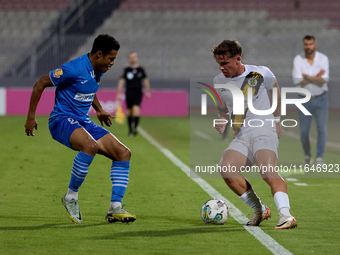 In Ta' Qali, Malta, on October 2, 2024, Enmy Manuel Pena Beltre of Marsaxlokk competes for the ball with Sean Gatt of Zabbar St. Patrick dur...