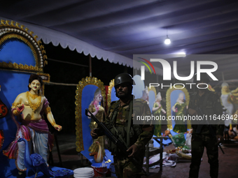 A member of the Bangladesh Army patrols at a temple ahead of the Durga Puja festival, the largest festival of the Hindu community, in Dhaka,...