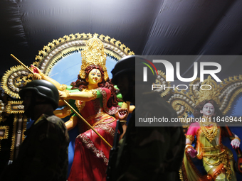 A member of the Bangladesh Army patrols at a temple ahead of the Durga Puja festival, the largest festival of the Hindu community, in Dhaka,...