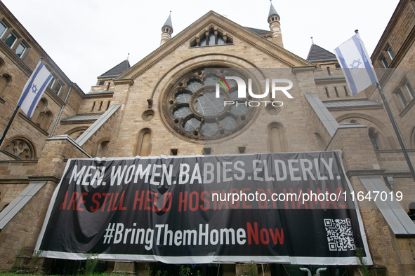 The large banner of ''bringthemhomenow'' hangs on the Roonstrasse Synagogue in Cologne, Germany, on October 7, 2024. 