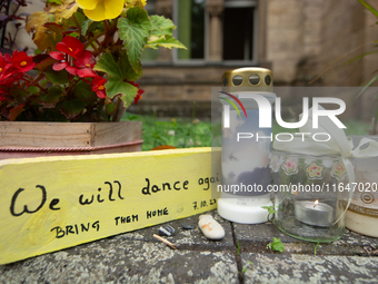 The candlelight and flowers are seen in front of the Roonstrasse Synagogue in Cologne, Germany, on October 7, 2024. (