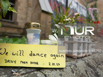 The candlelight and flowers are seen in front of the Roonstrasse Synagogue in Cologne, Germany, on October 7, 2024. (