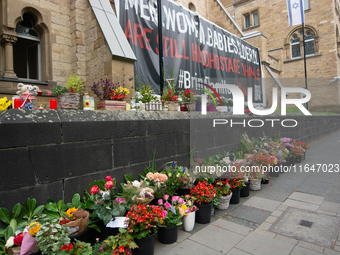 The candlelight and flowers are seen in front of the Roonstrasse Synagogue in Cologne, Germany, on October 7, 2024. (