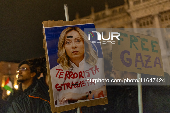 Pro-Palestinian protesters hold up a sign protesting against Prime Minister Meloni during demonstrations in Turin, Italy, on October 7, 2024...