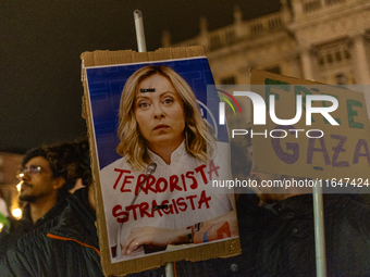 Pro-Palestinian protesters hold up a sign protesting against Prime Minister Meloni during demonstrations in Turin, Italy, on October 7, 2024...