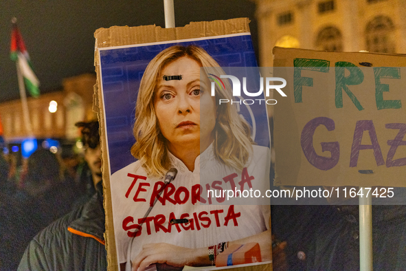 Pro-Palestinian protesters hold up a sign protesting against Prime Minister Meloni during demonstrations in Turin, Italy, on October 7, 2024...