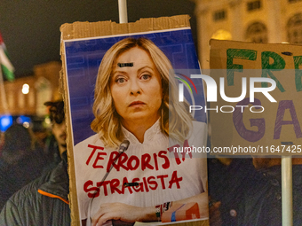 Pro-Palestinian protesters hold up a sign protesting against Prime Minister Meloni during demonstrations in Turin, Italy, on October 7, 2024...