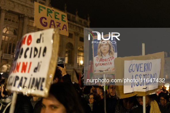 Pro-Palestinian protesters hold up a sign protesting against Prime Minister Meloni during demonstrations in Turin, Italy, on October 7, 2024...