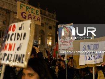 Pro-Palestinian protesters hold up a sign protesting against Prime Minister Meloni during demonstrations in Turin, Italy, on October 7, 2024...