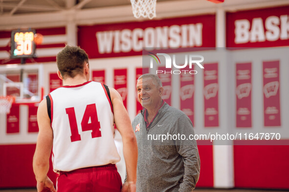 Hamilton High School Boys Basketball Coach Andy Cerroni surprises Wisconsin Badgers guard Aidan Konop #14 during local media day at the Nich...