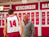 Hamilton High School Boys Basketball Coach Andy Cerroni surprises Wisconsin Badgers guard Aidan Konop #14 during local media day at the Nich...