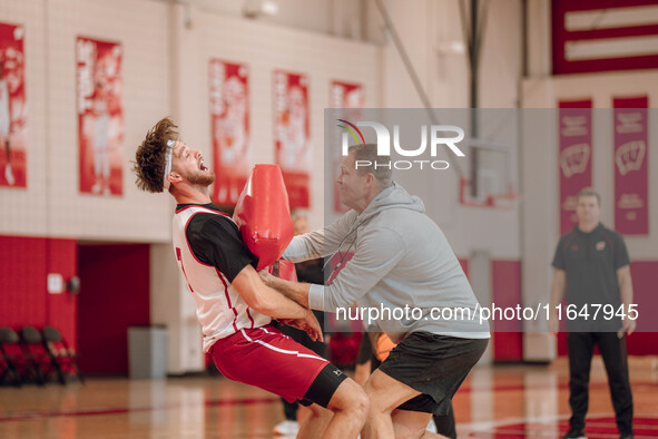 Wisconsin Badgers Associate Head Coach Joe Krabbenhoft hits forward Carter Gilmore #7 during a drill at the Nicholas Johnson Pavilion in Mad...