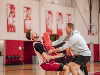 Wisconsin Badgers Associate Head Coach Joe Krabbenhoft hits forward Carter Gilmore #7 during a drill at the Nicholas Johnson Pavilion in Mad...