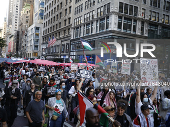 Palestinian supporters march through the streets with flags and signs against the October 2023 Israeli incursion of Gaza, on October 7, 2024...