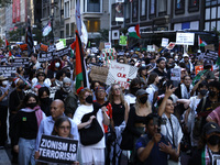 Palestinian supporters march through the streets with flags and signs against the October 2023 Israeli incursion of Gaza, on October 7, 2024...