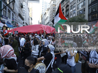 Palestinian supporters march through the streets with flags and signs against the October 2023 Israeli incursion of Gaza, on October 7, 2024...