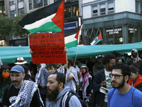 Palestinian supporters march through the streets with flags and signs against the October 2023 Israeli incursion of Gaza, on October 7, 2024...