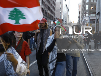 Palestinian supporters march through the streets with flags and signs against the October 2023 Israeli incursion of Gaza, on October 7, 2024...