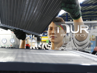 A worker works at the production workshop of Jiangsu Xinhua Auto Parts Co LTD in Sihong Economic Development Zone in Suqian, Jiangsu provinc...