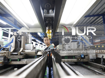 A worker works at the production workshop of Jiangsu Xinhua Auto Parts Co LTD in Sihong Economic Development Zone in Suqian, Jiangsu provinc...