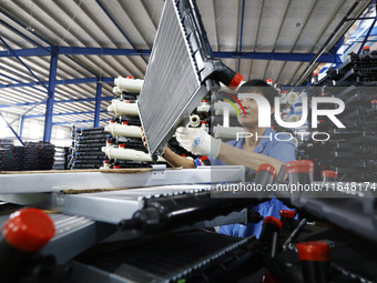 A worker works at the production workshop of Jiangsu Xinhua Auto Parts Co LTD in Sihong Economic Development Zone in Suqian, Jiangsu provinc...