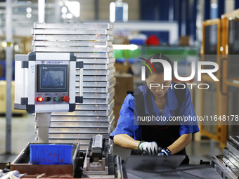 A worker works at the production workshop of Jiangsu Xinhua Auto Parts Co LTD in Sihong Economic Development Zone in Suqian, Jiangsu provinc...