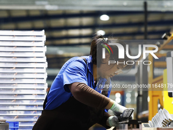 A worker works at the production workshop of Jiangsu Xinhua Auto Parts Co LTD in Sihong Economic Development Zone in Suqian, Jiangsu provinc...